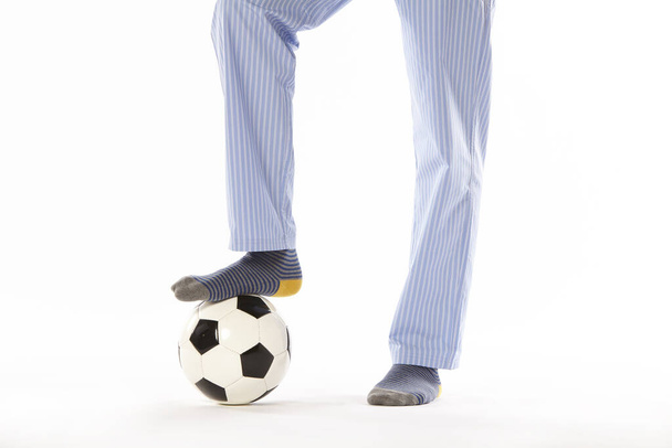 Egy fiatalember pizsamában focizik. Lábak. Éjszakai viselet - Fotó, kép