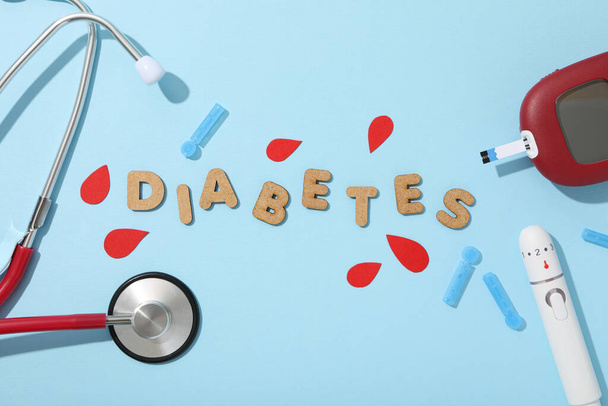 Medical equipment for diabetics and the word Diabetes on blue background, top view - Photo, Image