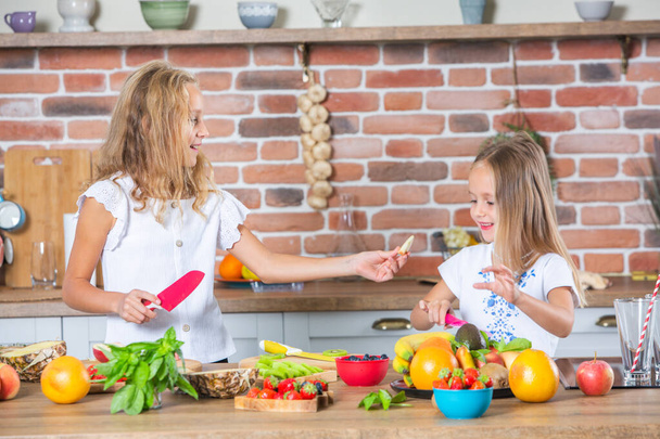 Šťastná matka a dcera se baví v kuchyni. Koncept zdravé stravy. - Fotografie, Obrázek