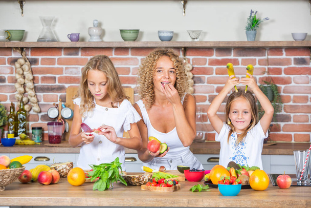 Madre e hija felices se están divirtiendo en la cocina. Concepto de comida saludable. - Foto, Imagen
