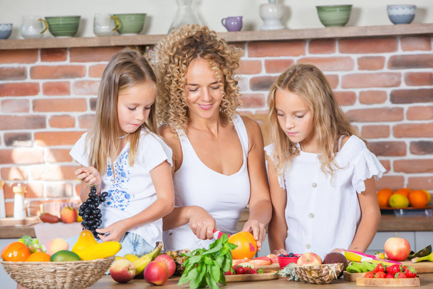 Glückliche Mutter und Tochter amüsieren sich in der Küche. Konzept für gesunde Ernährung. - Foto, Bild