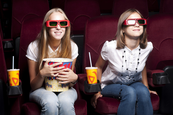 Two beautiful girls watching a movie at the cinema - Foto, immagini
