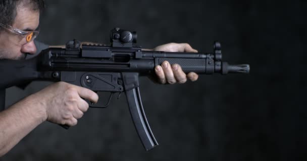 Вогнепальна зброя з високою швидкістю, HK SP5K GUN вид збоку. Людина, яка прицілюється і стріляє німецькою штурмовою гвинтівкою - Кадри, відео