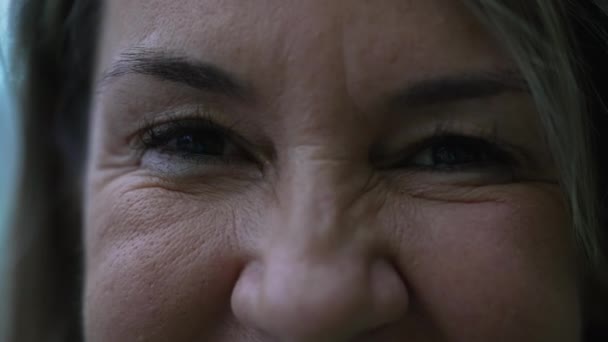 Extremo macro primer plano de una mujer feliz en sus 50 años mirando a la cámara sonriendo - Imágenes, Vídeo
