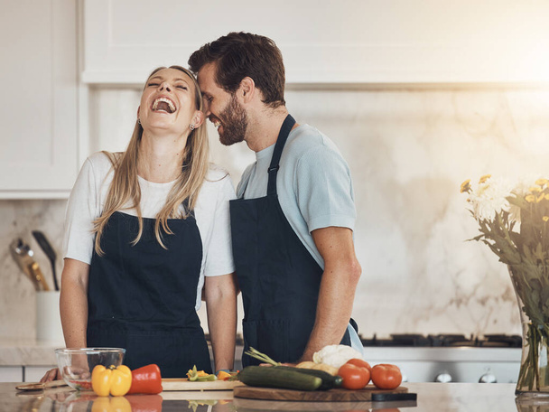 Funny, kitchen and couple with a smile, cooking and bonding with love, happiness and lunch. Home, man and woman with humor, food and ingredients with health, wellness and marriage with relationship. - Photo, Image