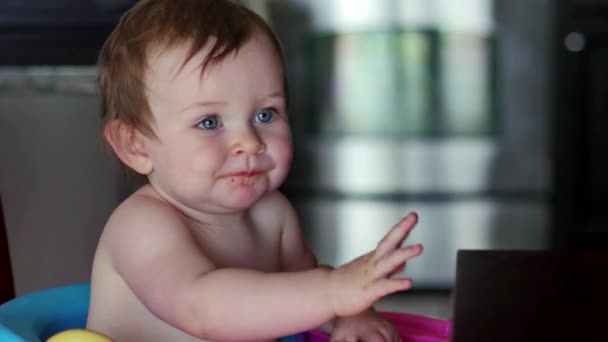 Cute baby waves and smiles while eating dinner - Footage, Video