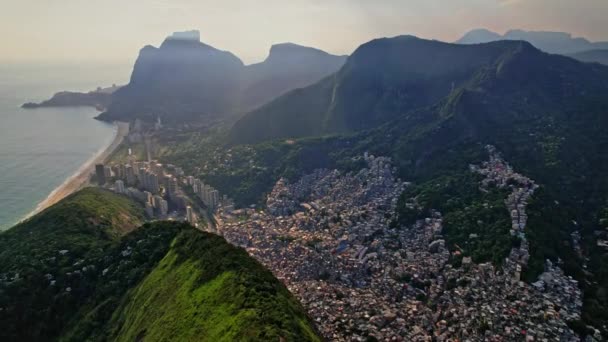 Drohnenaufnahmen des Gebirges Dois Irmaos in Rio de Janeiro in Brasilien. Die Aufnahmen beginnen mit Dolly-Bewegungen und Vogelperspektive auf die Berge und nach der Favela Rocinha. - Filmmaterial, Video