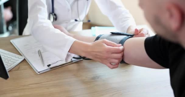 El cardiólogo terapeuta mide la presión arterial del paciente masculino. Concepto de medicina y salud - Metraje, vídeo