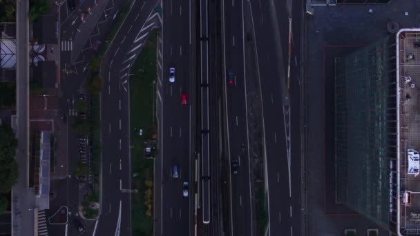 Shora dolů záběr provozu na víceúrovňové hlavní silnici a železniční trati. Vozidla projíždějící městem za soumraku. Paříž, Francie. - Záběry, video