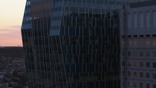 Εναέρια ανοδική πλάνα από γυάλινη πρόσοψη του σύγχρονου ουρανοξύστη γραφείων στην επιχειρηματική περιοχή La Defense το σούρουπο. Παρίσι, Γαλλία. - Πλάνα, βίντεο