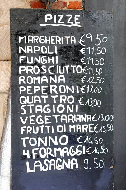 Доска с перечнем всех пицц, как и с многочисленными флажками, написанными на итальянском языке, и ценой в евро - Фото, изображение