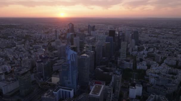 Fly above metropolis at dusk. Group of modern high rise downtown office buildings in La Defense. Colorful sunset sky. Paris, France. - Footage, Video