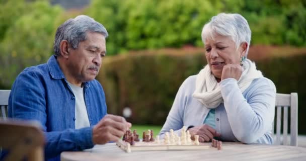 Idősebb férfi, nő és sakk a parkban a verseny, verseny vagy problémamegoldás asztalnál a természetben. Pár, nyugdíjas vagy vintage társasjáték kihívás, döntés vagy gondolkodás stratégia kertben. - Felvétel, videó