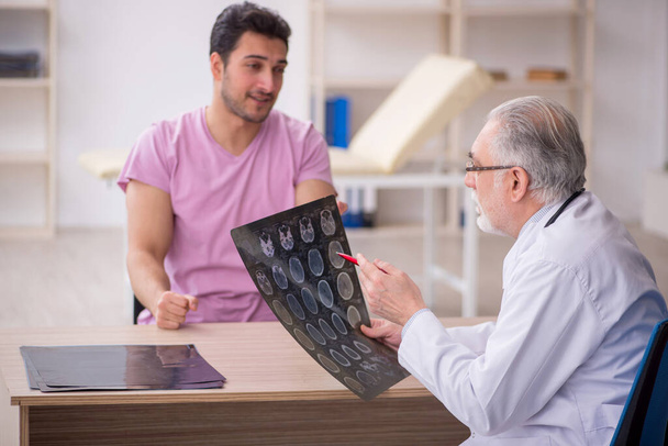 Giovane paziente visita vecchio medico radiologo - Foto, immagini