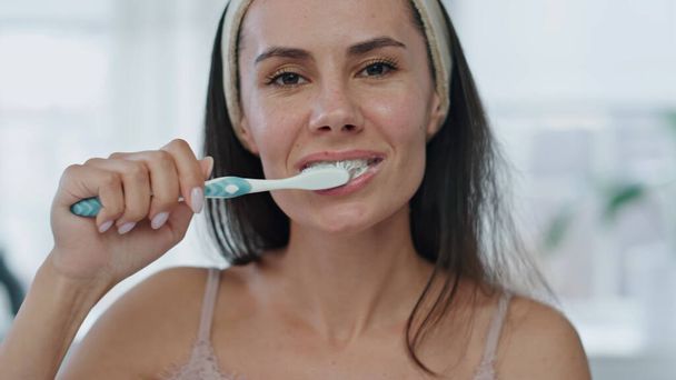 お風呂場で朝歯を磨くのが好き。幸せな女の子の口を閉じてガムをマッサージします。自宅の肖像画で口腔衛生の世話を歯科衛生を行う積極的な女性。白い笑顔のコンセプト - 写真・画像