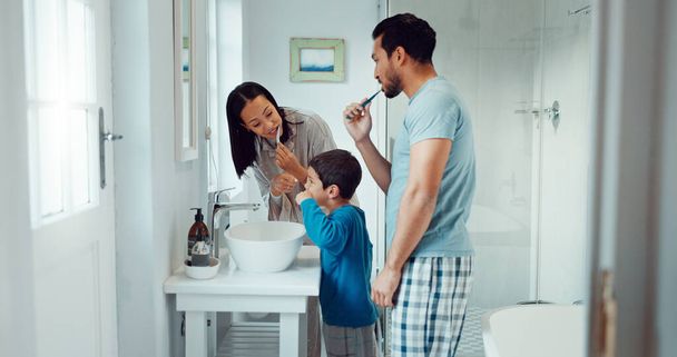 Батьки, дитина та чистячі зуби у сімейній домашній ванній кімнаті під час навчання або викладання гігієни зубів. Жінка, чоловік і дитина з зубною щіткою і зубною пастою для здоров'я, очищення рота і здоров'я. - Фото, зображення