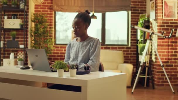 Freelancer afro-americano começando o dia em casa, resolvendo tarefas para o projeto de e business. Mulher trabalhando em laptop e respondendo e-mails na mesa, autônomo blogueiro teleworker. - Filmagem, Vídeo