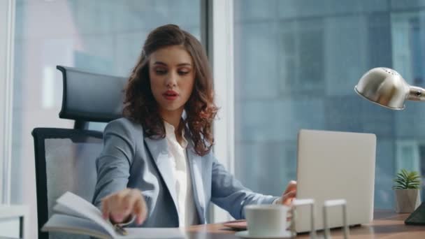 Επιτυχημένη κυρία αφεντικό πληκτρολογώντας laptop έλεγχο πληροφοριών από notebook closeup. Αυτοπεποίθηση όμορφη γυναίκα διευθυντής εργάζεται στην έκθεση γραφής του υπολογιστή. Νέα επιχειρηματίας που κάθεται σύγχρονο γραφείο στο χώρο εργασίας - Πλάνα, βίντεο