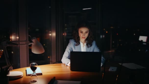 Überlastete Büroangestellte schließen müde Augen und schauen in der Nacht auf Laptop. Unzufriedene Geschäftsfrau, die am Computer-Monitor zusieht, fühlt sich am Arbeitsplatz des Unternehmens überfordert. Müde Managerin tippt PC. - Filmmaterial, Video