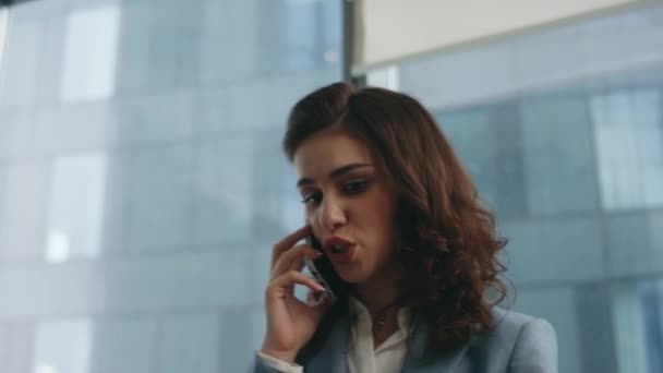 Mujer loca hablando de teléfono inteligente en disputa por el fracaso del negocio en el primer plano del lugar de trabajo. Mujer de negocios furiosa gritando a los trabajadores por teléfono de pie en la ventana panorámica de la oficina. Señora enojada problema decepcionado - Metraje, vídeo