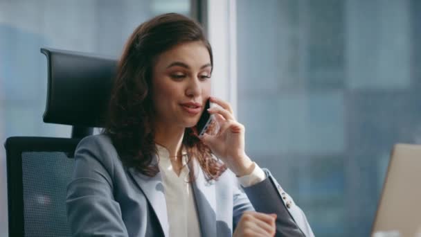 Girl business consultant calling sitting office desk with laptop close up. Happy beautiful businesswoman talking telephone satisfied conversation. Young successful woman manager smiling speaking phone - Footage, Video