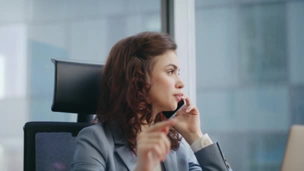 Γυναίκα με αυτοπεποίθηση μιλάει κινητό τηλέφωνο κάθεται πολυτελή χώρο εργασίας σε κομψό κοστούμι από κοντά. Ελκυστική επιτυχημένη επιχειρηματίας έχουν επαγγελματική κλήση στο σύγχρονο γραφείο. Έξυπνο κορίτσι διευθυντής μιλώντας smartphone. - Πλάνα, βίντεο