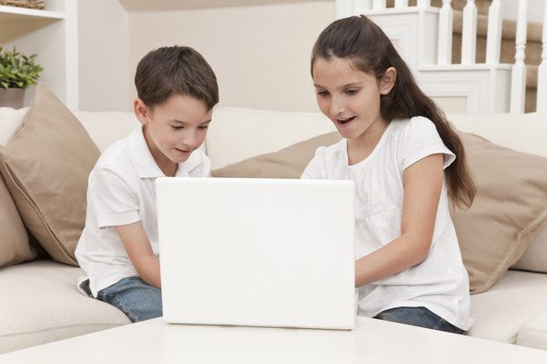 Poika & Tyttö lapset käyttävät kannettavaa tietokonetta kotona
 - Valokuva, kuva