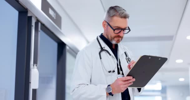 Doctor, man and hospital charts, documents or checklist for healthcare research, services and management in clinic. Surgeon or medical expert thinking of solution with clipboard or planning health. - Footage, Video
