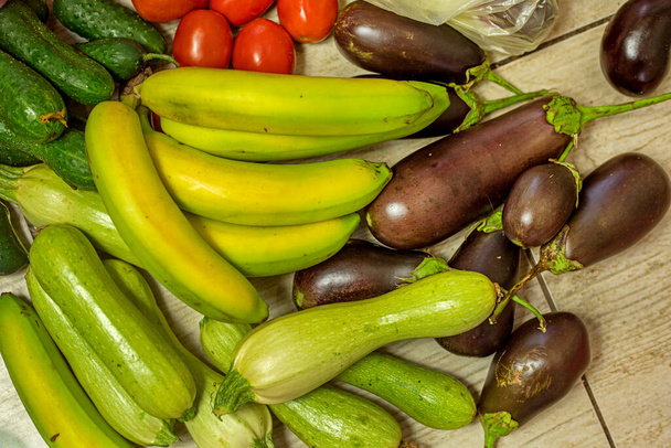 mazzo di banane verdi si trovano accanto a zucchine verdi, melanzane, cetrioli, pomodori, home shopping - Foto, immagini