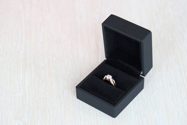 Δαχτυλίδι χρυσό διαμάντι σε μαύρο κουτί σε λευκό φόντο close up - Φωτογραφία, εικόνα