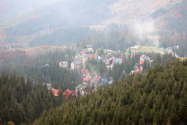 Vista matutina del área residencial y casas alrededor de los picos de las montañas Dragobrat en las montañas Cárpatas, Ucrania. Paisaje nublado y nebuloso alrededor de los picos Drahobrat temprano en la mañana - Foto, Imagen