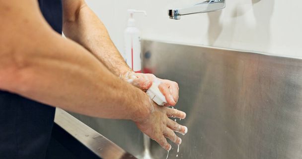 Dokter, handen en zeep wassen voor operatie, hygiëne en ziekte. Persoon, chirurg en closeup voor bereiding, reiniging of bescherming in de geneeskunde voor gezondheidszorg, ziekenhuis of kliniek. - Foto, afbeelding
