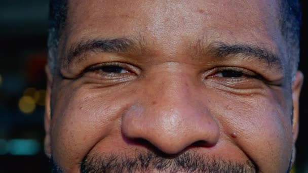 One happy black man macro close-up eyes staring at camera. Joyful Brazilian person eye detail - Footage, Video