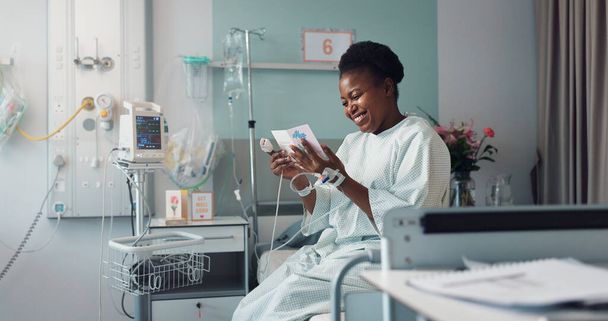 Woman, reading card and bed in hospital for message, get well soon or motivation with smile, hope and recovery. Patient, excited and gratitude for kindness, love or quote with gift for rehabilitation. - Photo, Image