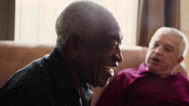 Idősebb férfi mosolyog, egy barátságos fekete idősebb ember nevet közelről. Karizmatikus afro-amerikai valós élet nevetés és mosoly - Felvétel, videó