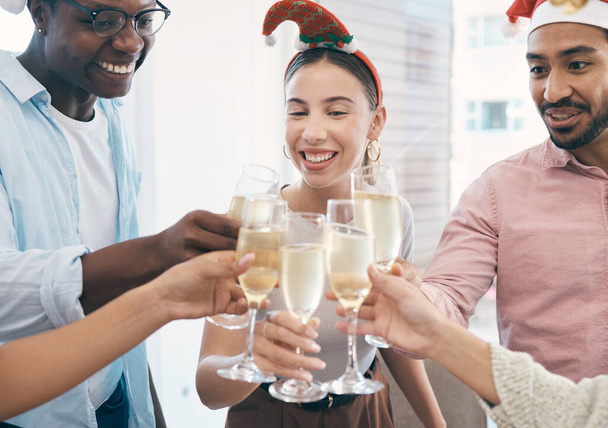 Шампанское, рождественская вечеринка и тосты с группой людей в офисе, празднование и веселье с праздником и алкоголем. Вино, приветствия и сотрудники на рабочем мероприятии на Рождество, счастье и разнообразие с напитками. - Фото, изображение