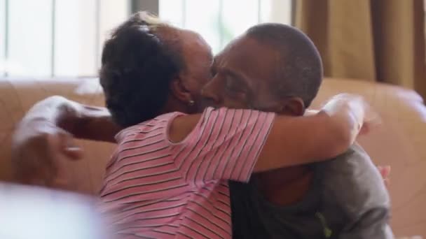 Autentico momento di affetto di un figlio adulto nero che abbraccia la madre anziana. Abbraccio di vita reale tra membri della famiglia - Filmati, video