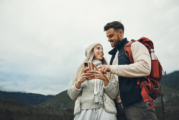 Çift, telefon ve seyahat ya da doğa içinde bilgi, sosyal medya sohbet ya da açık hava yolculuğu için harita ile yürüyüş. Aşağıdaki mutlu insanlar sırt çantalarında ve dağlarda geziyorlar ya da yer arıyorlar.. - Fotoğraf, Görsel