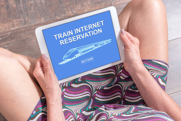 Kobieta siedząca na podłodze z tabletem pokazująca pojęcie rezerwacji Internetu pociągu - Zdjęcie, obraz
