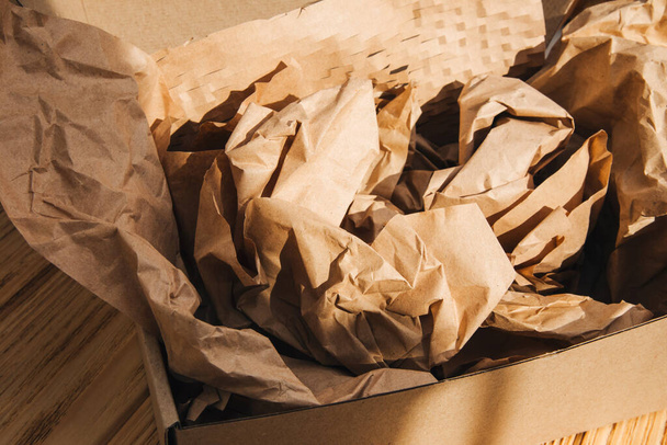 Packaging of eco-materials. Cardboard box and packaging paper on a light background. Concept saving the planet from undetectable debris. Top view - Photo, Image