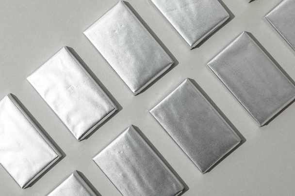 Chocolates em folha de prata no fundo cinza, vista superior - Foto, Imagem