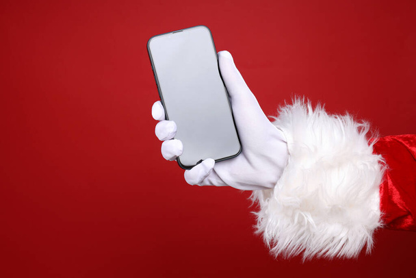 Νέο έτος έννοια, το χέρι του Αϊ Βασίλη με smartphone - Φωτογραφία, εικόνα