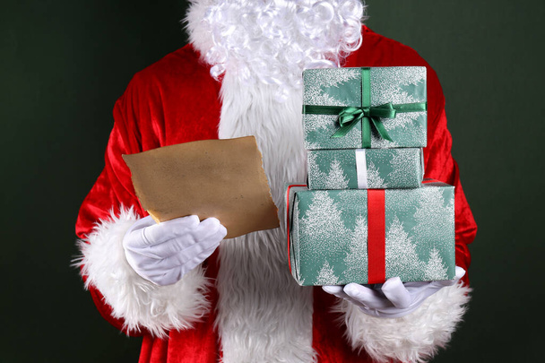 El concepto del nuevo año, la mano de Papá Noel con regalos - Foto, Imagen