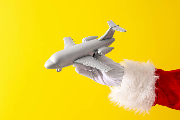 Nuovo concetto di anno, la mano di Babbo Natale con un aeroplano giocattolo - Foto, immagini