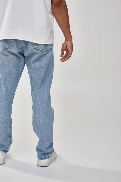 stijlvolle Afro-Amerikaanse man in trendy casual jeans en wit t-shirt, kopieer ruimte voor reclame - Foto, afbeelding