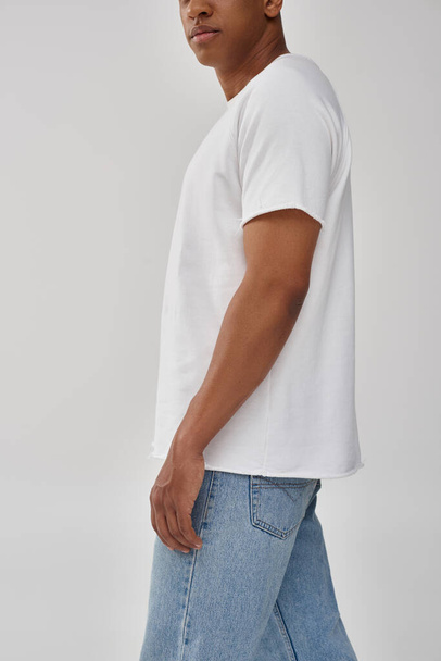 stylischer afrikanisch-amerikanischer Mann in trendigen lässigen Jeans und weißem T-Shirt, Kopierfläche für Werbung - Foto, Bild