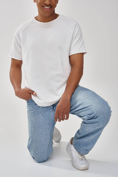 stylish african american man in trendy casual jeans and white t-shirt, copy space for advertising - Photo, Image