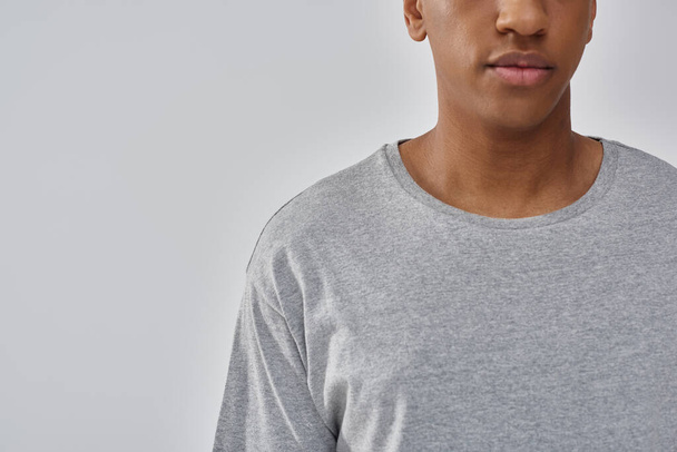 modischer junger afrikanisch-amerikanischer Mann in lässigem grauen T-Shirt, Kopierfläche für Werbung - Foto, Bild