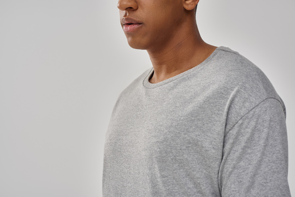 hombre afroamericano joven de moda que usa la camiseta gris casual, espacio de copia para la publicidad - Foto, imagen
