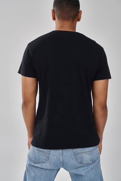 elegante modello afroamericano maschile in posa nera t-shirt e jeans, spazio copia per la pubblicità - Foto, immagini